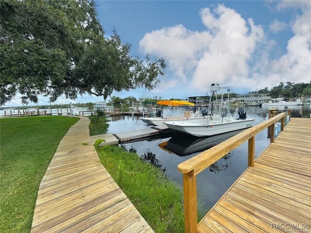 dock area featuring a lawn and a water view