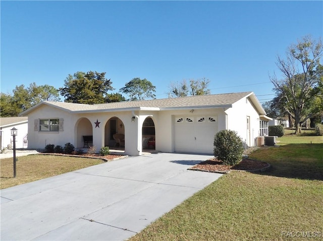 ranch-style home with a garage, a front yard, and central AC