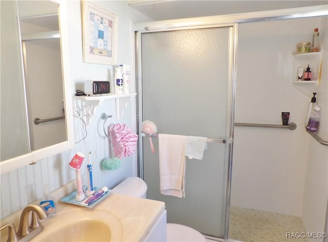 bathroom with vanity, a shower with shower door, and toilet