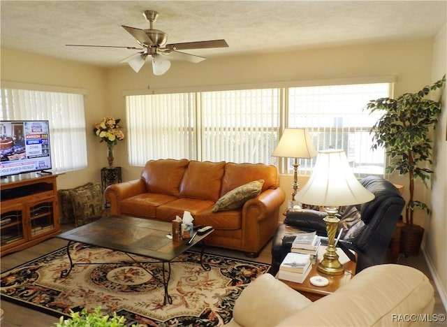 living room featuring ceiling fan and a textured ceiling