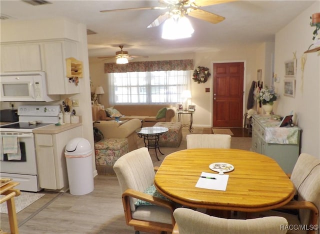 dining area with ceiling fan and light wood-type flooring