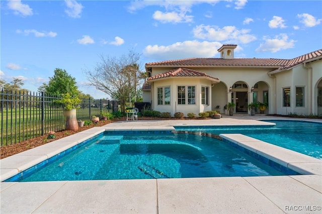 12380 SW 140th Loop, Dunnellon, FL 34432 - back of property featuring stucco siding, a tile roof, fence, a patio area, and a pool with connected hot tub