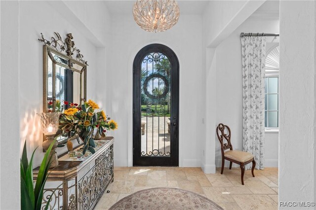12380 SW 140th Loop, Dunnellon, FL 34432 - entryway with stone tile flooring, a chandelier, arched walkways, and baseboards