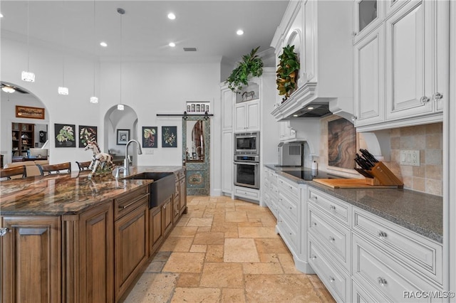 12380 SW 140th Loop, Dunnellon, FL 34432 - kitchen featuring appliances with stainless steel finishes, a sink, stone tile floors, arched walkways, and white cabinets