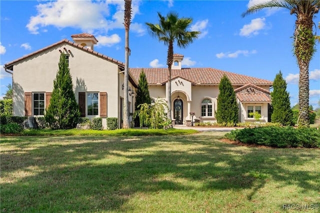 12380 SW 140th Loop, Dunnellon, FL 34432 - mediterranean / spanish-style house with a tile roof, stucco siding, and a front lawn
