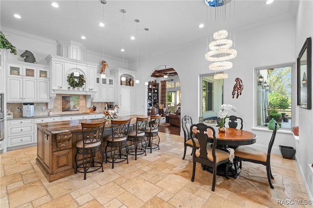 12380 SW 140th Loop, Dunnellon, FL 34432 - kitchen featuring stone tile flooring, crown molding, recessed lighting, a kitchen breakfast bar, and decorative backsplash