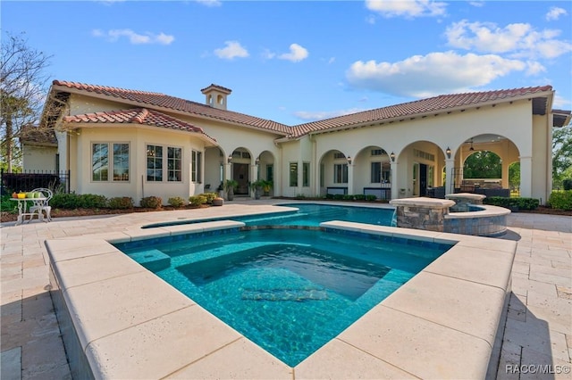 12380 SW 140th Loop, Dunnellon, FL 34432 - back of property with a tiled roof, a patio, a pool with connected hot tub, stucco siding, and fence