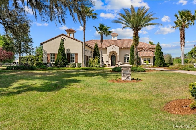 12380 SW 140th Loop, Dunnellon, FL 34432 - mediterranean / spanish-style home featuring stucco siding, a front lawn, and a tiled roof