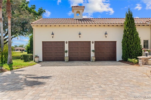 12380 SW 140th Loop, Dunnellon, FL 34432 - view of front of property with a tiled roof, decorative driveway, stucco siding, and a garage