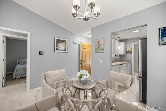 dining room featuring an inviting chandelier, sink, and vaulted ceiling