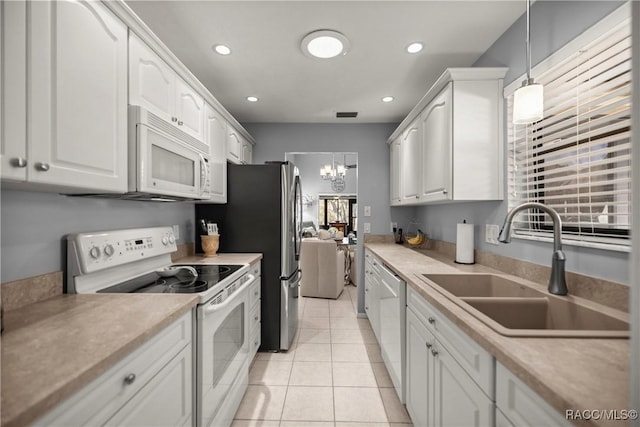 kitchen with white cabinetry, sink, white appliances, and pendant lighting