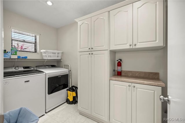 clothes washing area featuring cabinets and independent washer and dryer