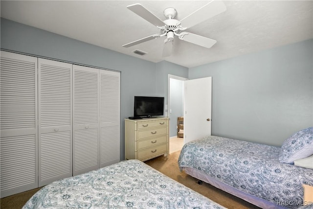 bedroom with ceiling fan, carpet, and a closet