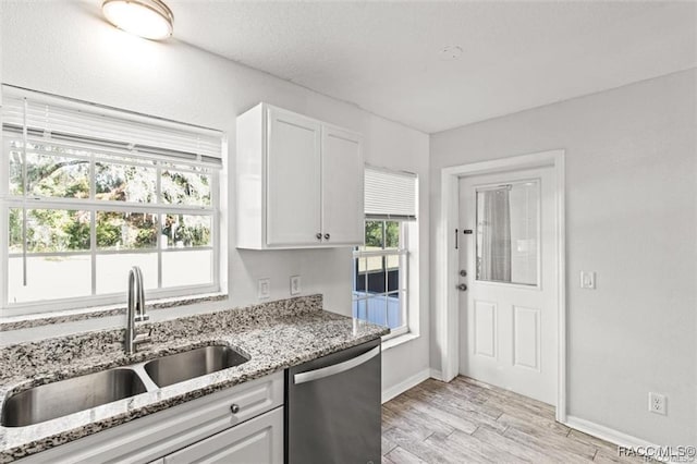 kitchen featuring sink, light hardwood / wood-style flooring, dishwasher, light stone counters, and white cabinets