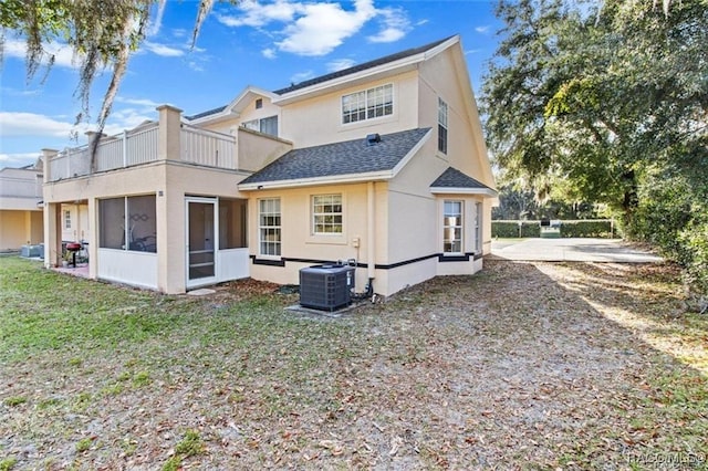 back of property with a yard, central AC, and a sunroom