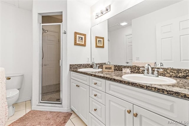 bathroom with tile patterned flooring, vanity, a shower with door, and toilet