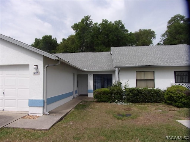 ranch-style house with a garage and a front yard