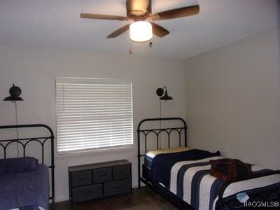 bedroom featuring ceiling fan and dark hardwood / wood-style flooring