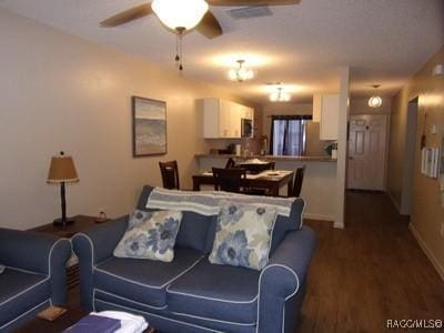 living room with dark hardwood / wood-style floors and ceiling fan