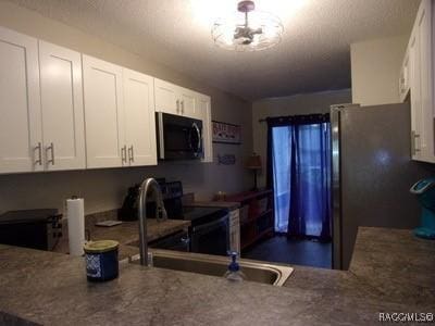 kitchen featuring white cabinetry, range with electric stovetop, stainless steel fridge, and a chandelier