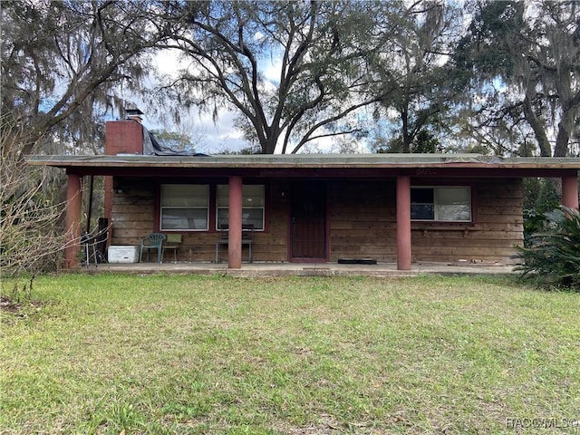 view of front of property with a chimney and a front lawn