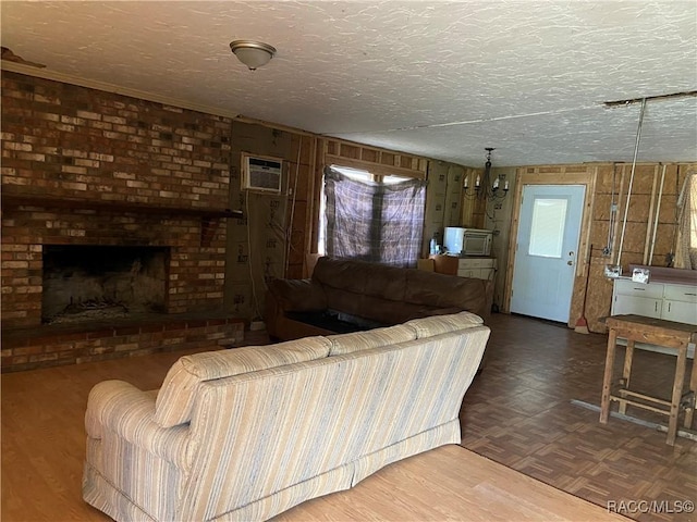 living area with a textured ceiling, a fireplace, a wall mounted air conditioner, and parquet flooring