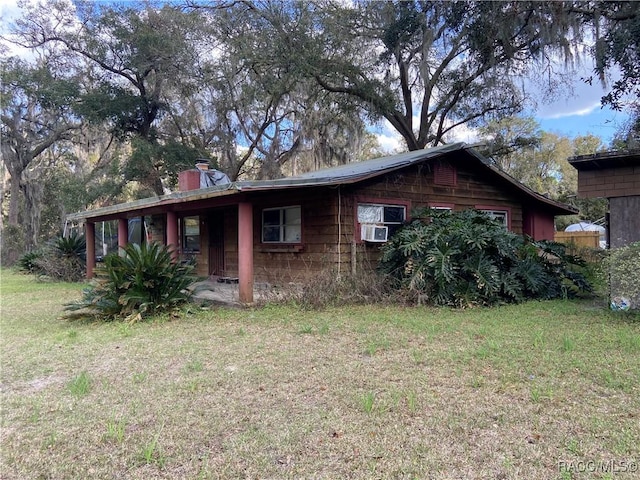 view of front facade with cooling unit and a front lawn