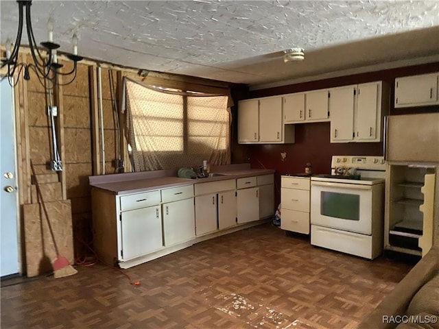 kitchen with electric stove, dark floors, a sink, and white cabinets