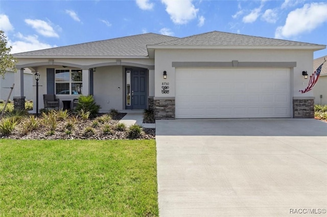 single story home featuring concrete driveway, stone siding, an attached garage, a front lawn, and stucco siding