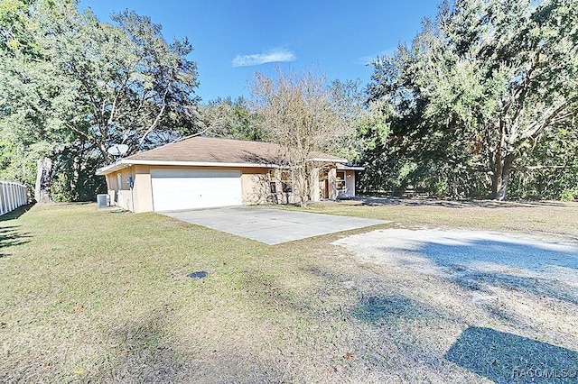 view of front of property with central AC unit, a garage, and a front yard