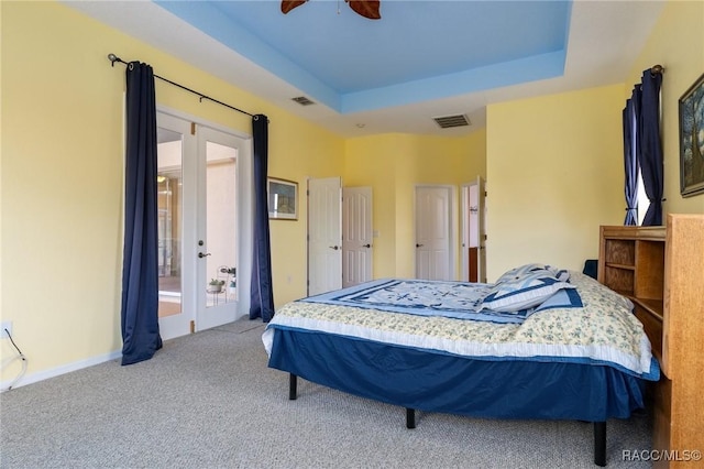 bedroom featuring ceiling fan, a raised ceiling, and french doors