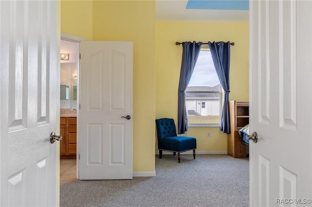 carpeted bedroom featuring ensuite bathroom and multiple windows