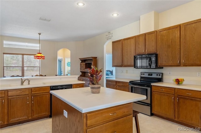 kitchen with sink, electric range, decorative light fixtures, a kitchen island, and light tile patterned flooring