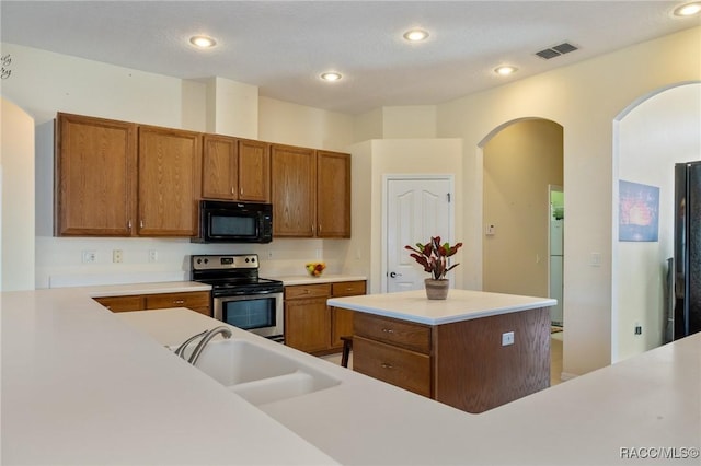 kitchen featuring black appliances, a kitchen island, and sink