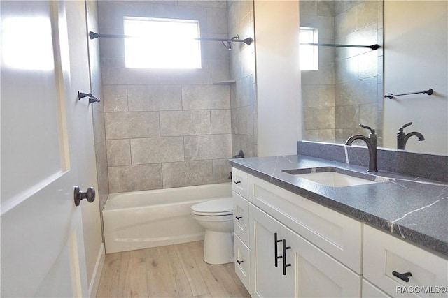 bathroom with vanity, toilet, shower / bathtub combination, and wood finished floors