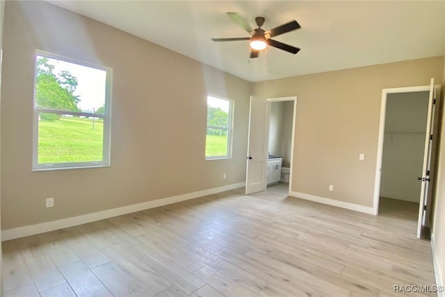 786 E Dunbar Ln, Hernando, FL 34442 - unfurnished bedroom with a spacious closet, light wood finished floors, connected bathroom, and ceiling fan