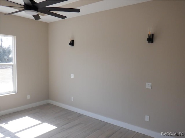 empty room featuring baseboards, light wood finished floors, and ceiling fan