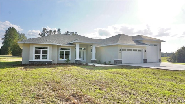 prairie-style house featuring stucco siding, a front yard, concrete driveway, and an attached garage