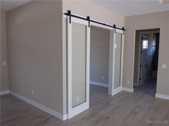 786 E Dunbar Ln, Hernando, FL 34442 - empty room featuring a barn door and light wood-style floors