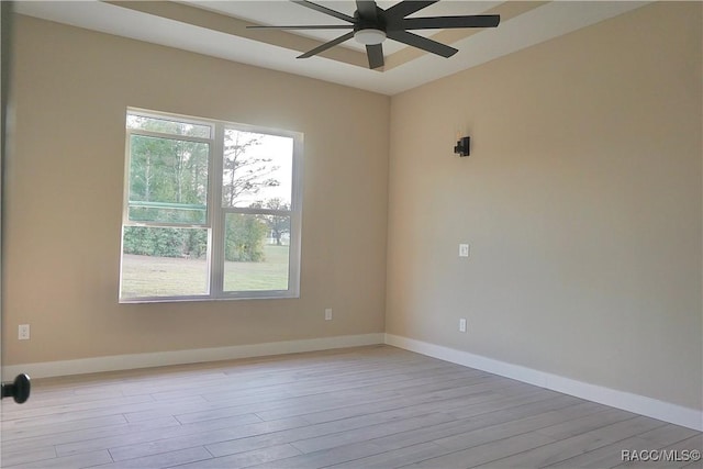 empty room with ceiling fan, baseboards, and wood finished floors