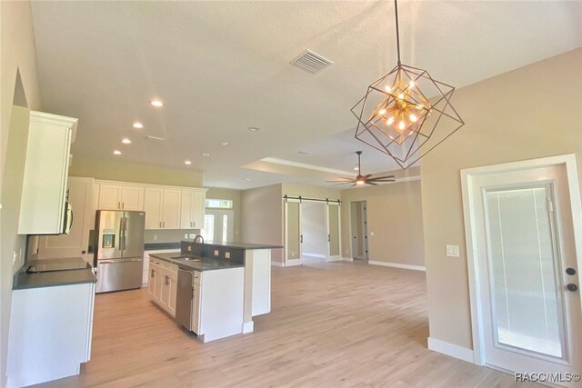 786 E Dunbar Ln, Hernando, FL 34442 - kitchen featuring stainless steel appliances, a barn door, dark countertops, white cabinets, and recessed lighting