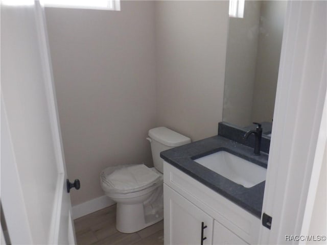 bathroom with vanity, wood-type flooring, and toilet