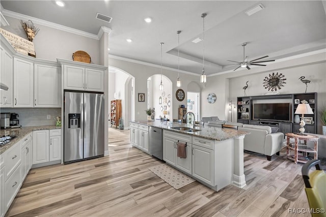 kitchen featuring sink, white cabinetry, hanging light fixtures, and appliances with stainless steel finishes