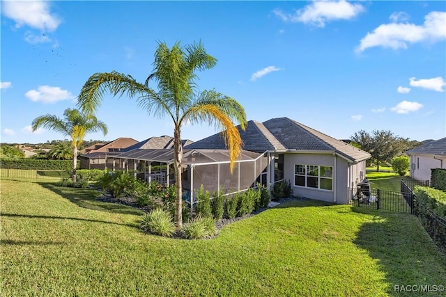 rear view of property featuring a yard and a lanai