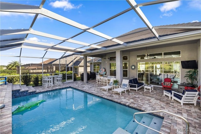 view of pool with a lanai, ceiling fan, and a patio