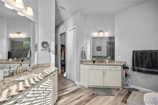 bathroom with a shower, vanity, and hardwood / wood-style flooring