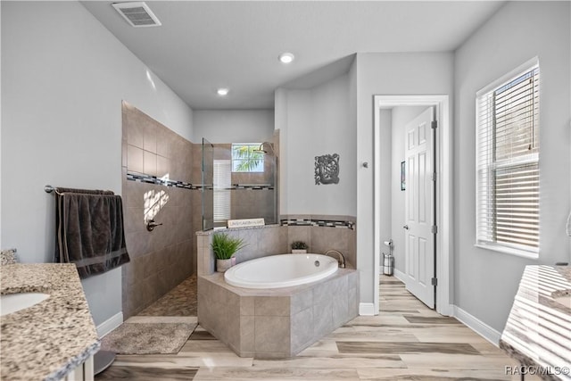 bathroom with vanity, separate shower and tub, and wood-type flooring