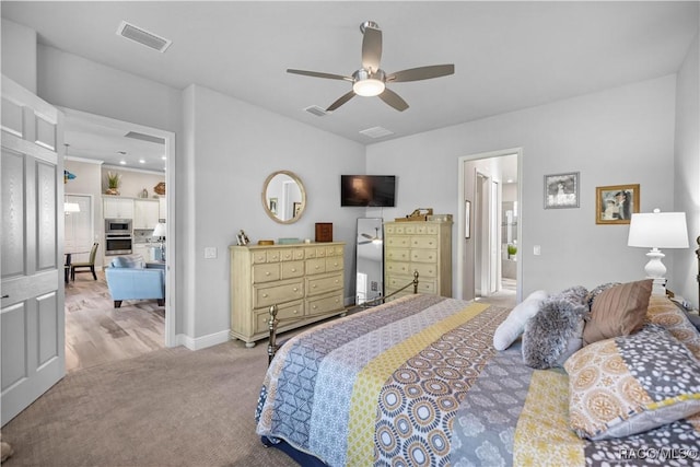 bedroom featuring connected bathroom, light colored carpet, and ceiling fan