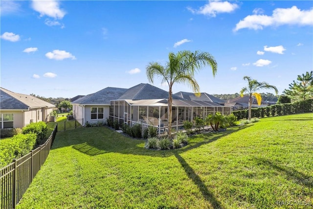 rear view of property featuring a lanai and a lawn