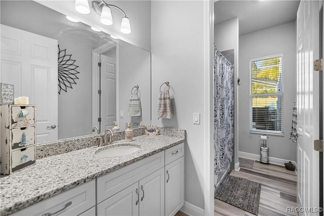 bathroom featuring curtained shower, hardwood / wood-style floors, and vanity